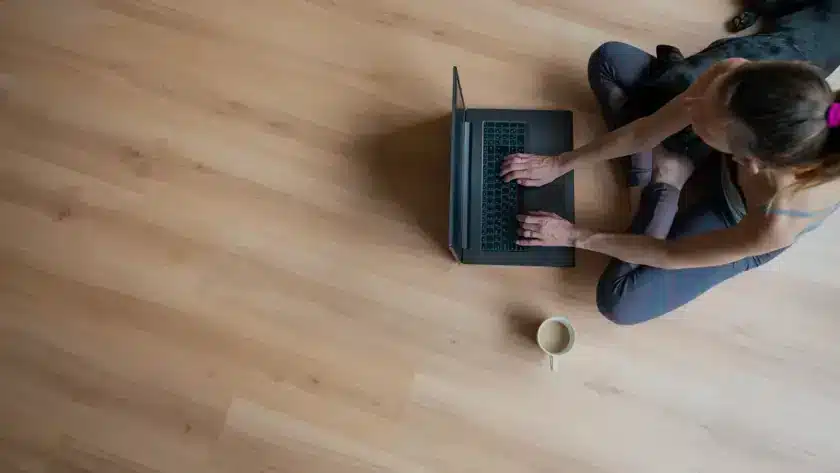 Woman working on a laptop on light oak vinyl plank flooring in an Ontario home