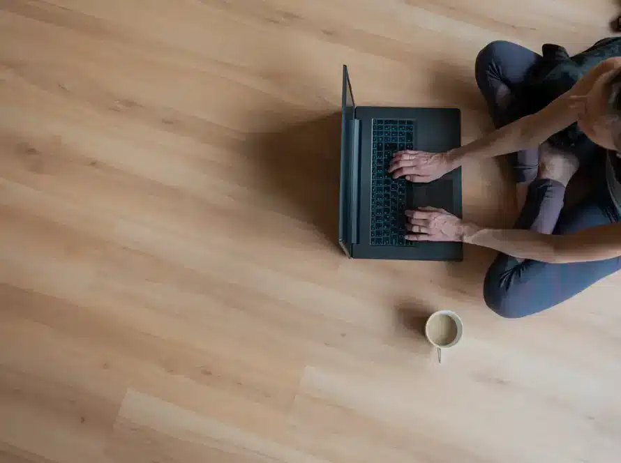 Woman working on a laptop on light oak vinyl plank flooring in an Ontario home